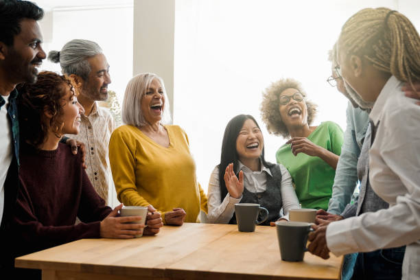 istock Happy multiethnic people drinking tea during lunch break at work - Group of multi-generational friends having fun laughing together - Soft focus on Asian senior man face 1692429693