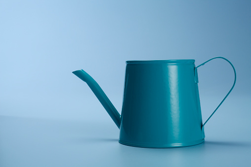 Watering can isolated on the blue background.