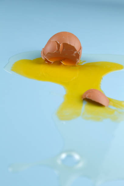 istock cracked egg shell and spilled egg white and yolk on blue background 1692441313