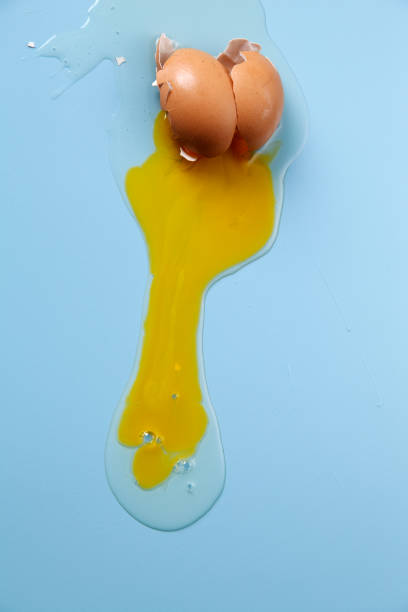 istock cracked egg shell and spilled egg white and yolk on blue background 1692442419
