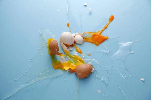 istock cracked egg shell and spilled egg white and yolk on blue background 1692442984