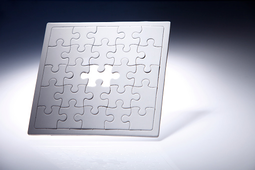 Puzzle with missing piece isolated on the grey background.