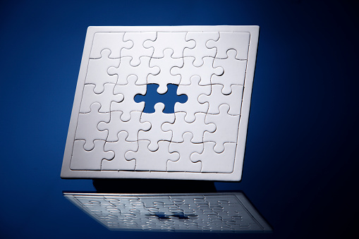 Jigsaw puzzle with missing piece isolated on blue background.