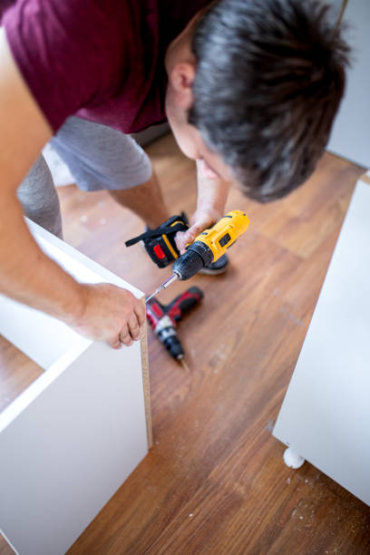 istock Close up of man holding electrical battery screwdriver while assembling wooden kitchen elements 1692484452