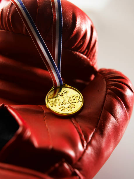 nahaufnahme der medaille auf dem boxhandschuh - bronze medal boxing glove medal gold medal stock-fotos und bilder