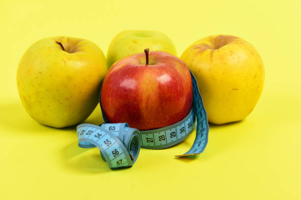 istock Measuring tape or flexible ruler in blue color and apples 1692505981
