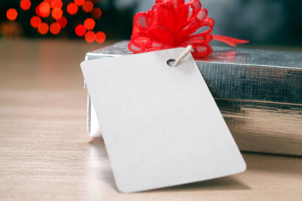 istock Christmas present with blank tag against  defocus christmas tree. 1692534528