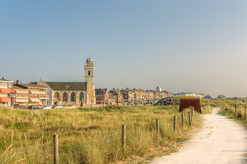 Katwijk aan Zee, Netherlands - July 20, 2021: View of the boulevard of Katwijk aan Zee with the Andreas Church as a landmark