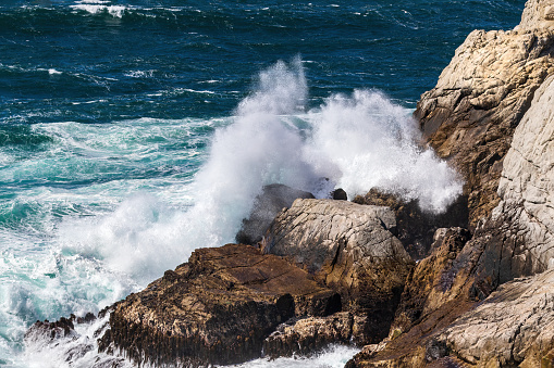 Big wave splash over rocky coast. Location: Porto, west coast of Corsica, France.