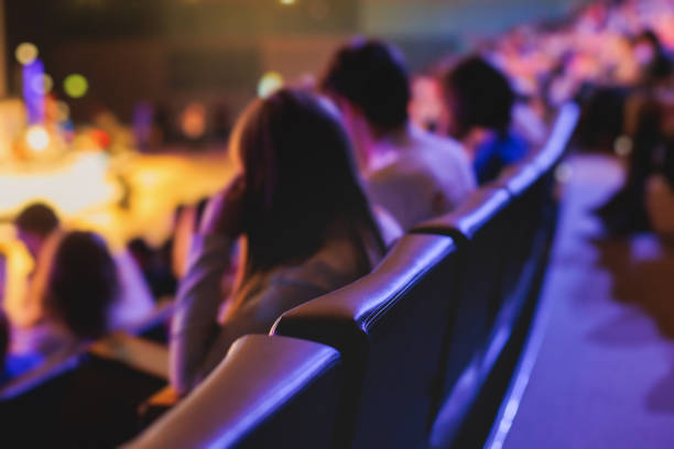 istock Audience at the modern conference hall listens to panel discussion, people on a congress together listen to speaker on stage at convention, business seminar, amphitheater venue for congress 1692553267