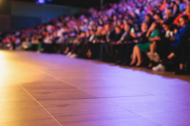 audience at the modern conference hall listens to panel discussion, people on a congress together listen to speaker on stage at convention, business seminar, amphitheater venue for congress - event convention center business hotel imagens e fotografias de stock