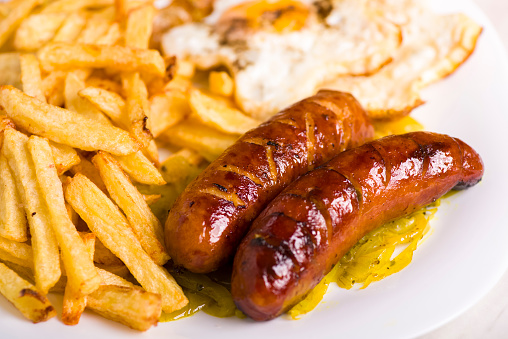 grilled sausage served with fries and salad