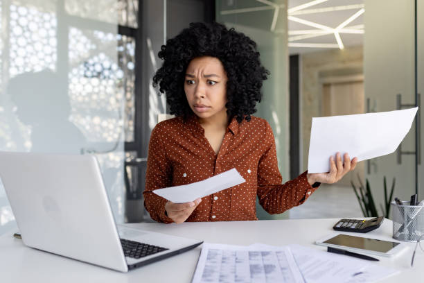 istock Sad and disappointed businesswoman inside office at workplace looking at documents papers financial reports, african american female worker on paper work depressed unhappy with financial achievements 1692576463