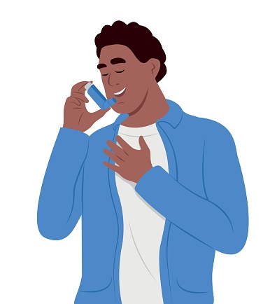 Young smiling black man uses an asthma inhaler against attack. World asthma day. Bronchial asthma. Allergy, asthmatic. Inhalation drug.