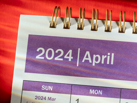 Tax day marked on April 2020 monthly calendar with 1040 form and pen