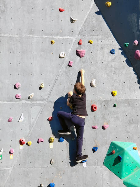 istock A teenage boy is crawling on a rock climbing wall in training. 1692603005