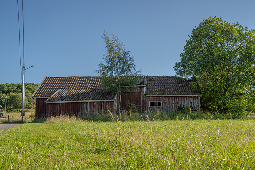 Old abandoned red barn in a field.