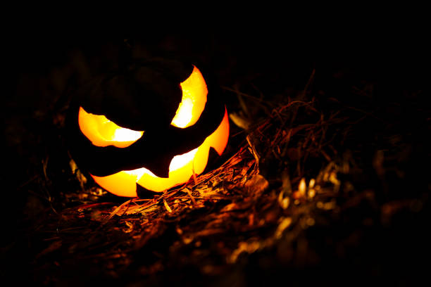 Halloween pumpkin Jack o Lantern glowing at night