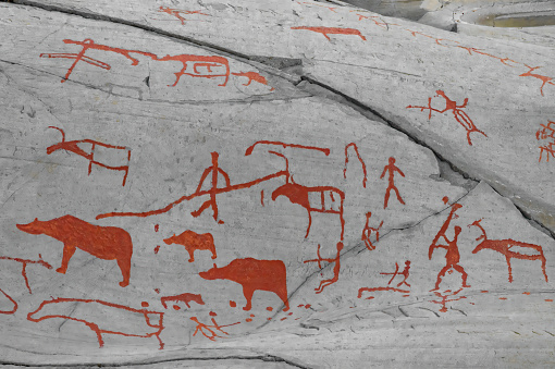Mesmerizing prehistoric rcok carvings and red ochre paintings Alta, Troms og Finnmark county, Norway.. Hunting scenes