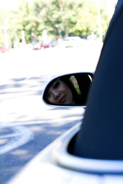 istock Asian American Woman Reflected In Side View Mirror On Car 1692634881