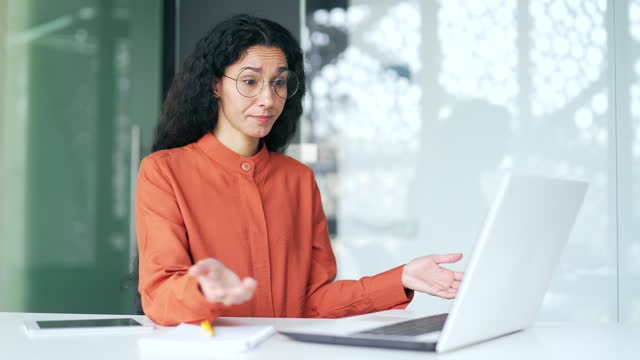 Frustrated female employee complains about poor performance of computer program on laptop while sitting in office.