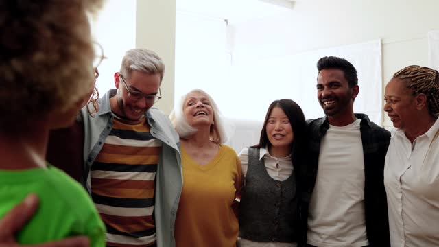 Happy multiethnic people celebrating together - Group of multi-generational friends having fun hugging and supporting each other