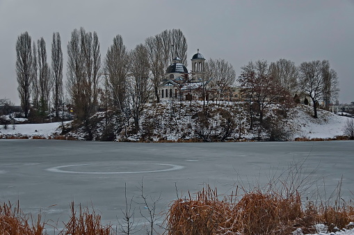 Frozen lake and church with modern architecture in winter in Drujba quarter, Sofia, Bulgaria