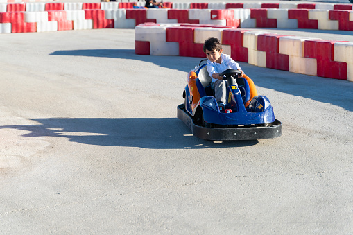 boy driving a battery-powered vehicle in a gokart. The child receives traffic training with a battery-powered vehicle. Taken in daylight with a full frame camera.