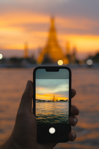 Smartphone screen of video of Wat Arun temple in Bangkok at sunset