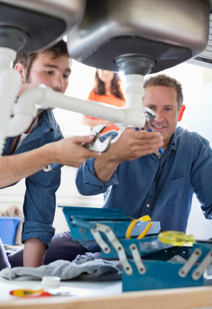 mecânicos hidráulicos trabalhando em tubos com pia de cozinha - plumbing supplies - fotografias e filmes do acervo