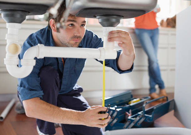 Plumber working on pipes under kitchen sink  Plumber stock pictures, royalty-free photos & images