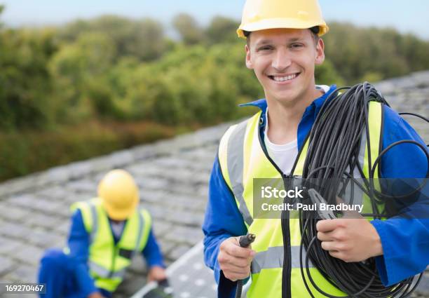 Worker Smiling On Rooftop Stock Photo - Download Image Now - Electrician, Solar Panel, Solar Energy