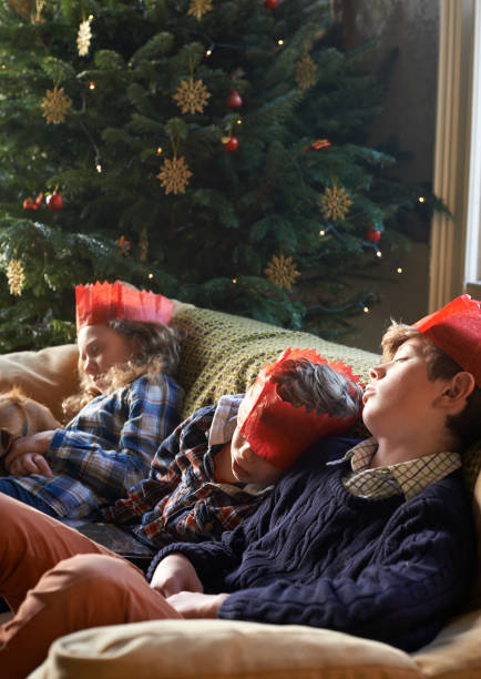 istock Children in paper crowns sleeping on sofa 169270480