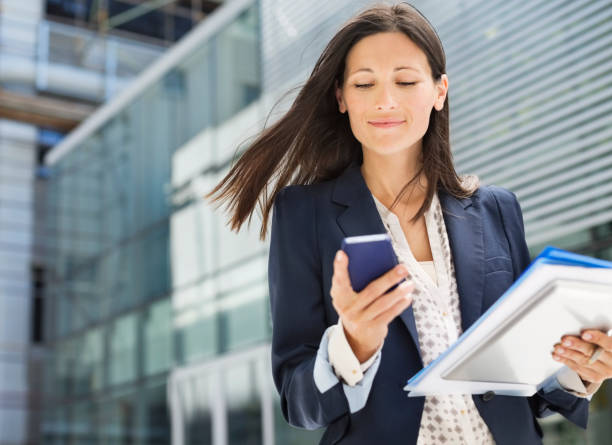 geschäftsfrau mit handy im büro - women digital tablet outdoors smiling stock-fotos und bilder