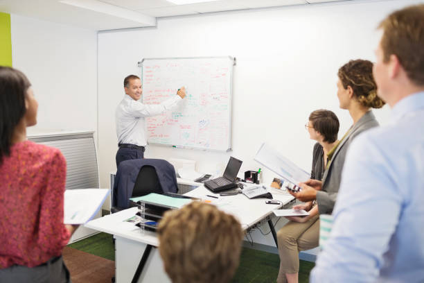 istock Businessman drawing on whiteboard in meeting 169270661
