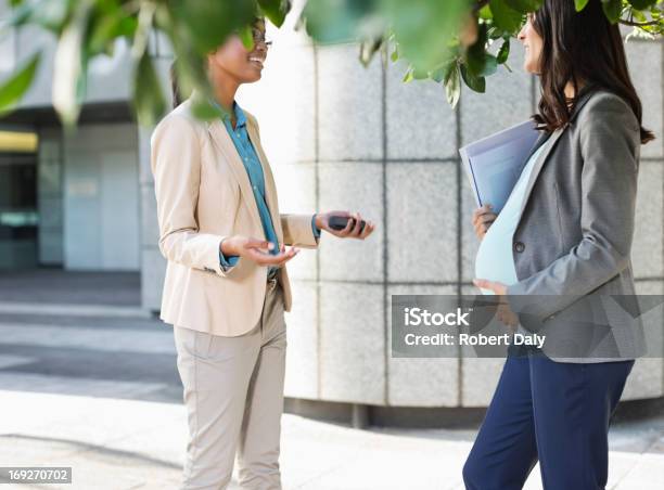 Businesswomen Talking On City Street Stock Photo - Download Image Now - 18-19 Years, 30-39 Years, 35-39 Years