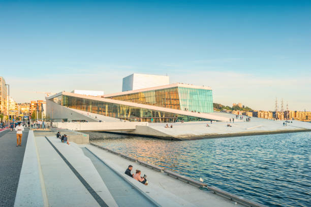 People relax on the promenade beside the Oslo Opera in downtown Oslo, Norway in the evening.