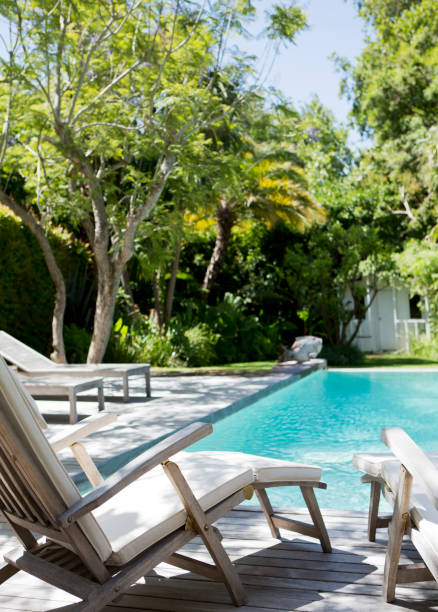 istock Lawn chairs and swimming pool in backyard 169271412