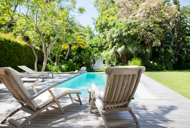 istock Lawn chairs and swimming pool in backyard 169271471