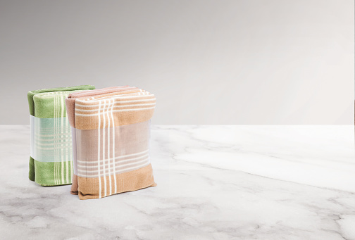 Folded set of blankets in packaging on a marble