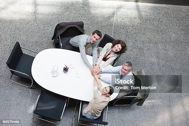 Photo libre de droit de Juste Audessus De La Clientèle Daffaires Amonceler Les Mains Sur La Table De Conférence banque d'images et plus d'images libres de droit de Affaires