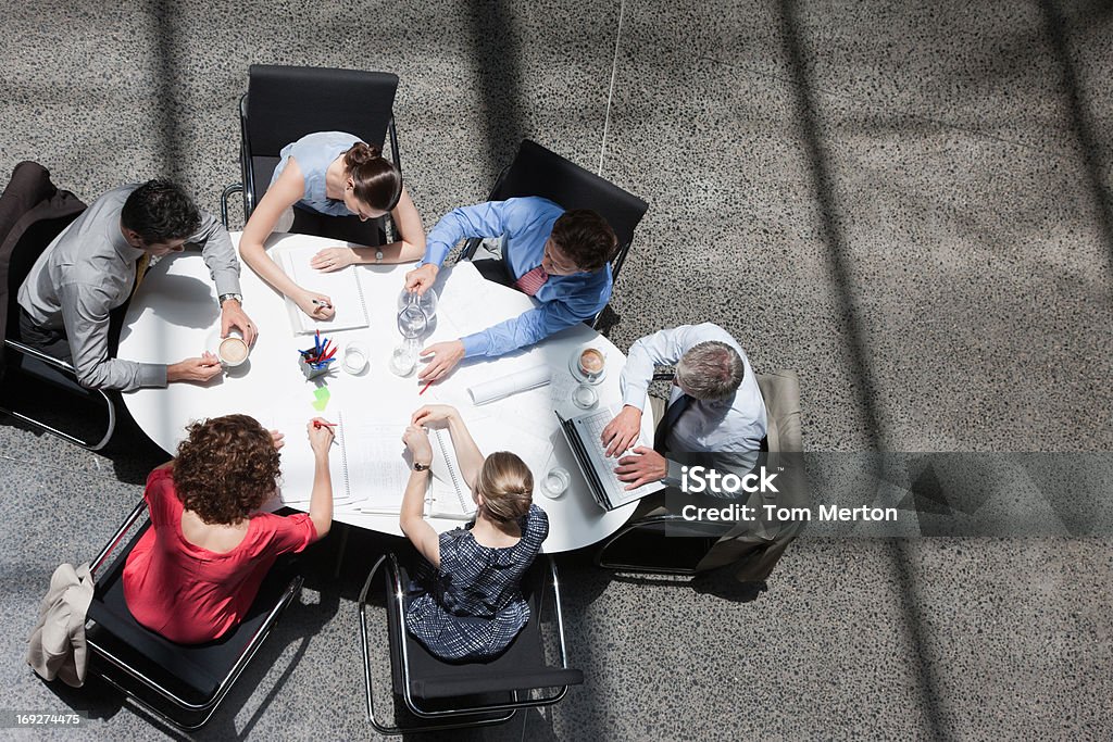 Empresarios reunidos alrededor de una mesa de conferencias - Foto de stock de Vista elevada libre de derechos