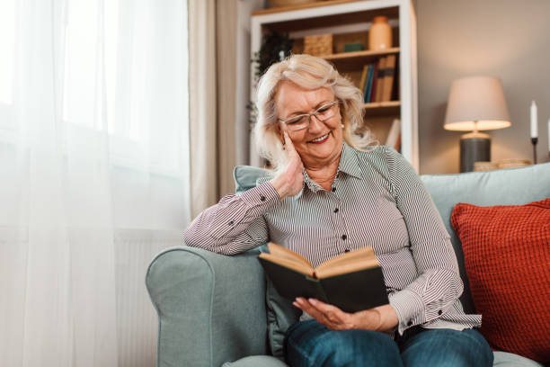 istock Senior woman sitting at home and reading a book. 1692773565