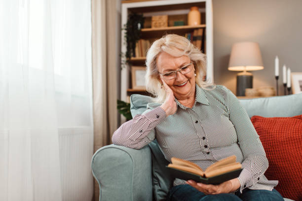 istock Senior woman sitting at home and reading a book. 1692774086