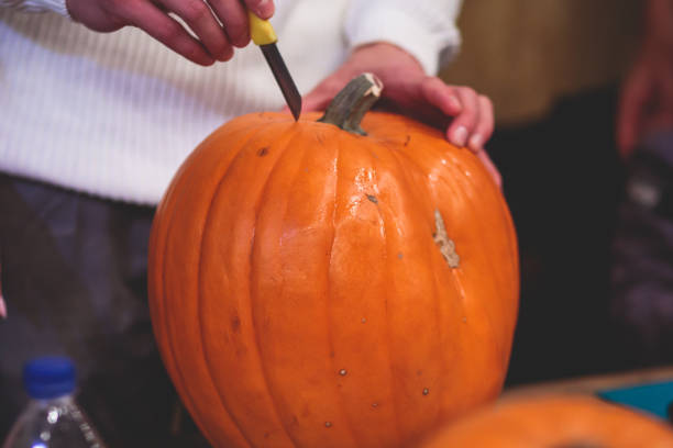 istock Process of making pumpkin lantern for halloween party, glowing jack-o-lantern carving master class on halloween fair market, orange decoration, illuminated carved pumpkin lanterns 1692785548