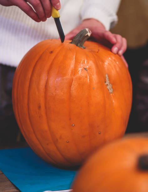 istock Process of making pumpkin lantern for halloween party, glowing jack-o-lantern carving master class on halloween fair market, orange decoration, illuminated carved pumpkin lanterns 1692785550