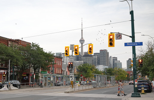 Toronto, Canada - August 21, 2023: Looking south on the 300-block of Spadina Avenue at Nassau Street. Pedestrians visit the Kensington-Chinatown neighborhood on a summer early evening.