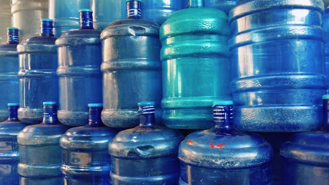 Tilt up  shot of stacks of refillable water gallons waiting to be refilled with safe clean drinking water in the Philippines.