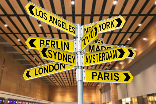 Road signs with travel locations in Whole world in an airport terminal