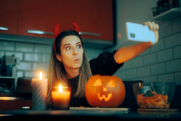istock Funny Halloween Woman Taking a Selfie with a Jack-o-Lantern 1692936192